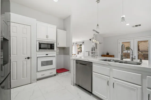 a kitchen with white cabinets and white appliances