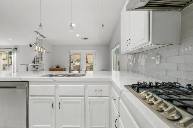 a kitchen with white cabinets and appliances