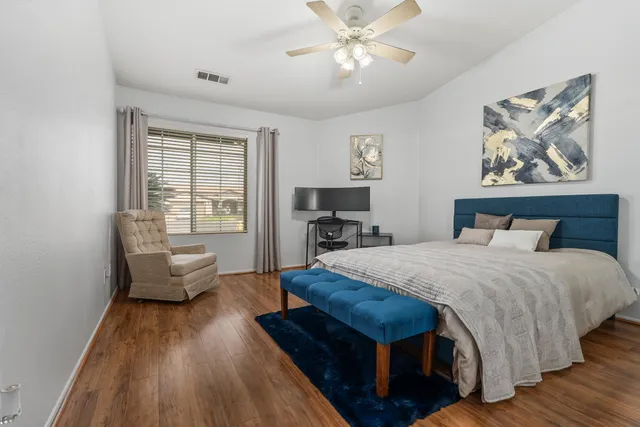 a bedroom with a bed and wooden floor