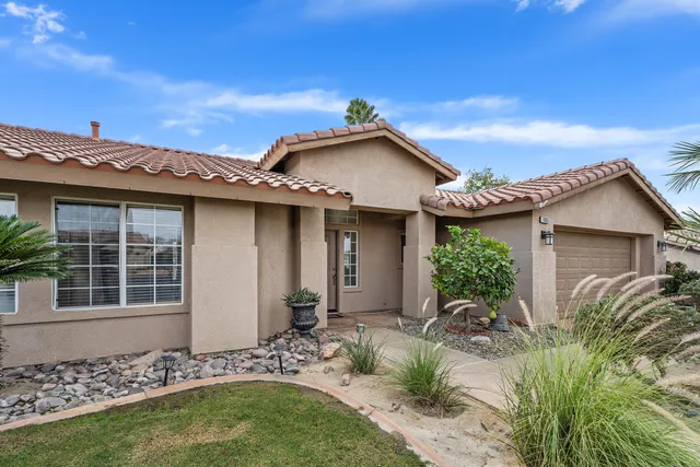 a front view of a house with plants