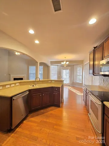 a large kitchen with stainless steel appliances granite countertop a large stove top oven and cabinets