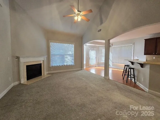 a view of an empty room with a fireplace and a window