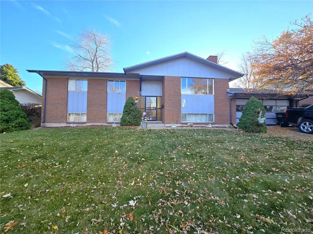 an empty room with wooden floor fireplace and windows