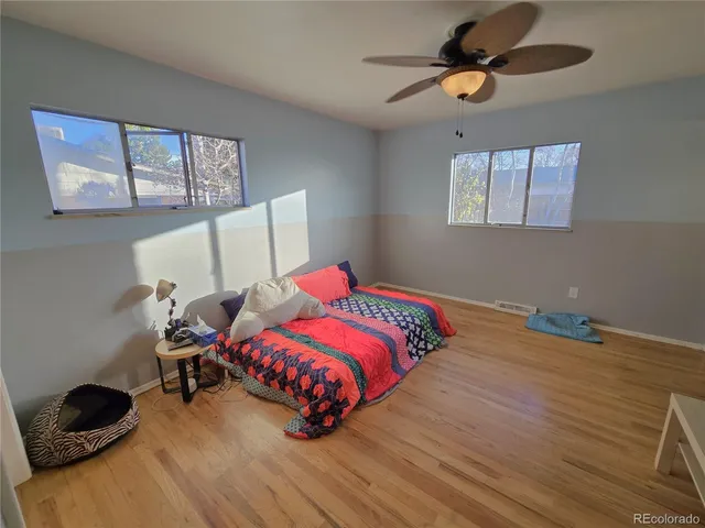 a bedroom with a bed and wooden floor