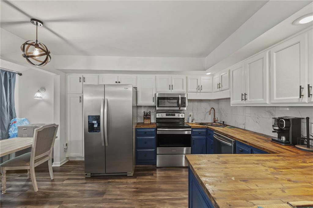 655 Riverside Drive Ellijay, GA 30540 - Photo 14 of 34 a kitchen with stainless steel appliances granite countertop a refrigerator a stove and a sink with cabinets