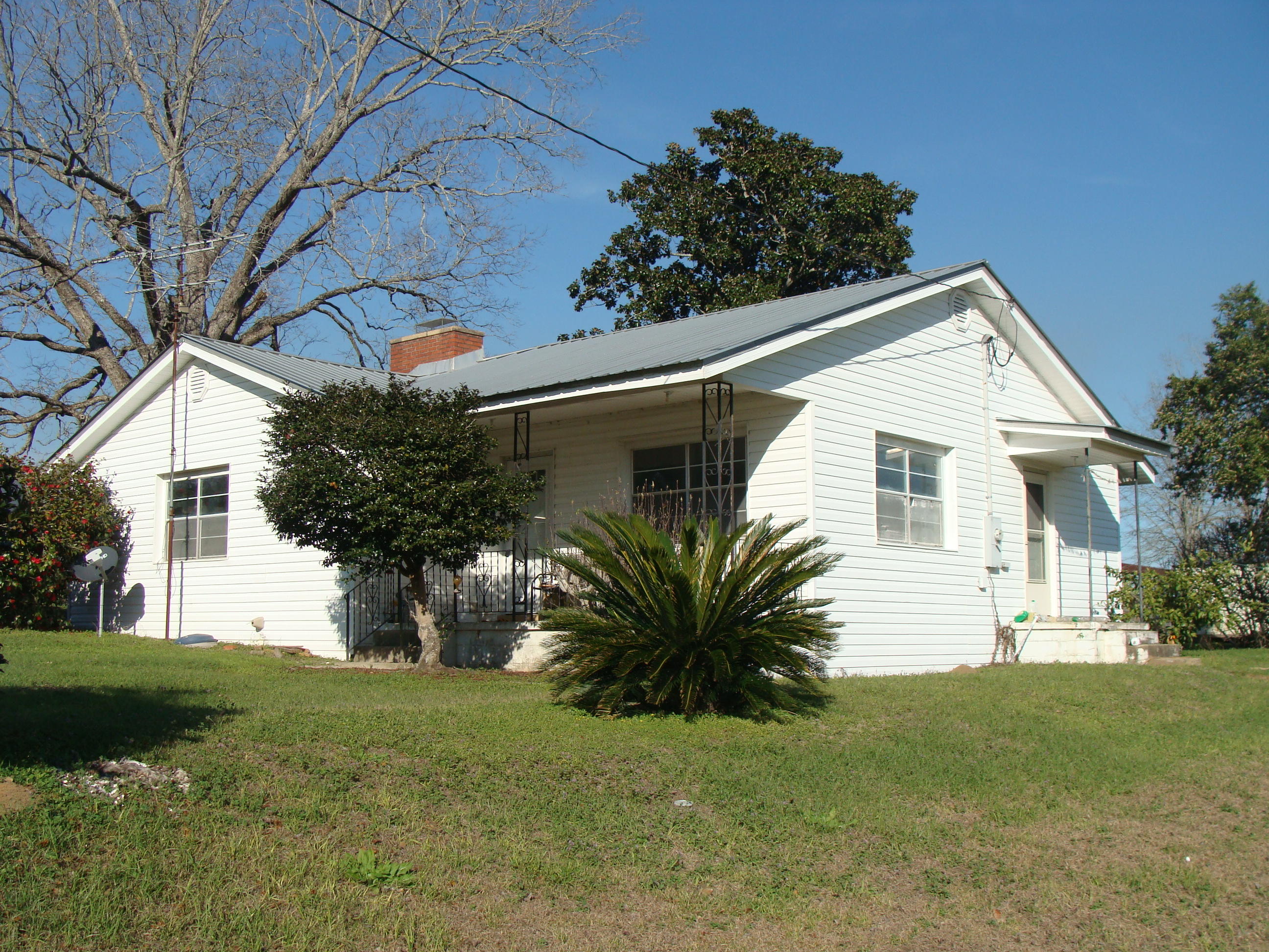 592 Mims Road DeFuniak Springs, FL 32433 - Photo 4 of 67 a view of a white house next to a yard with plants and trees