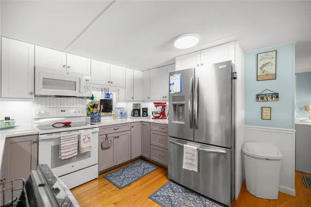 a kitchen with a sink a refrigerator and white cabinets