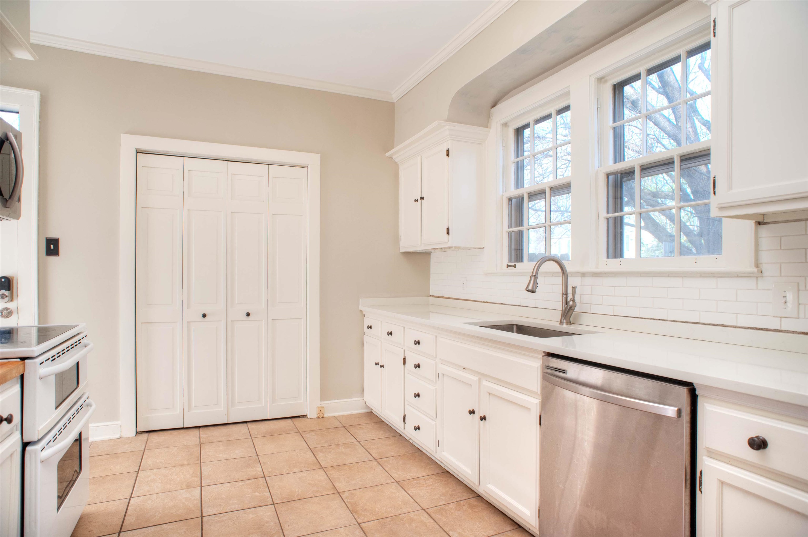 4756 Princeton Road Memphis, TN 38117 - Photo 6 of 22 a kitchen with granite countertop white cabinets white appliances with a sink and a window