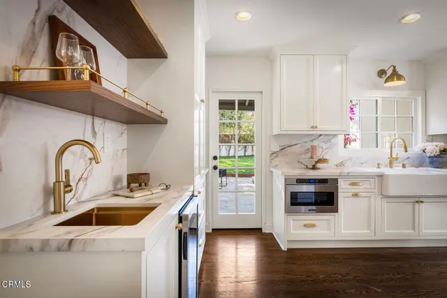 a large kitchen with a lot of counter space and wooden floor