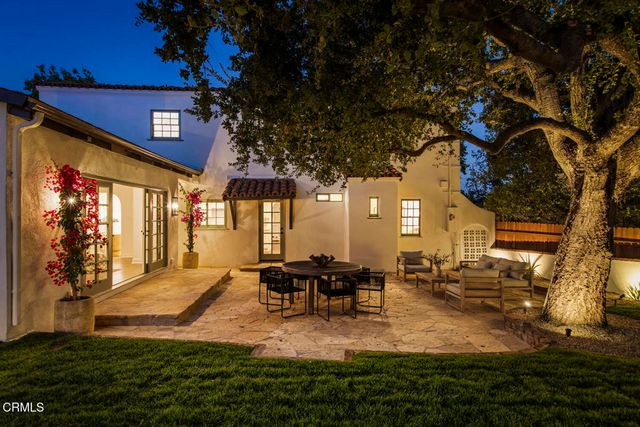 a view of a patio with dining table and chairs with a fire pit and a large tree