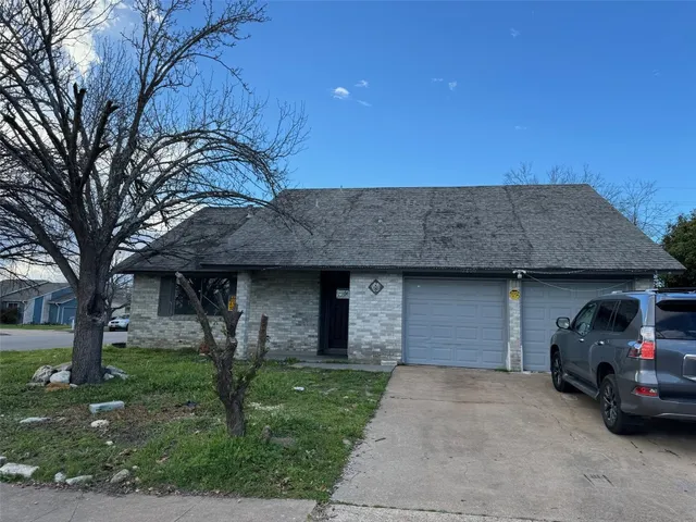 a front view of a house with a garden and garage