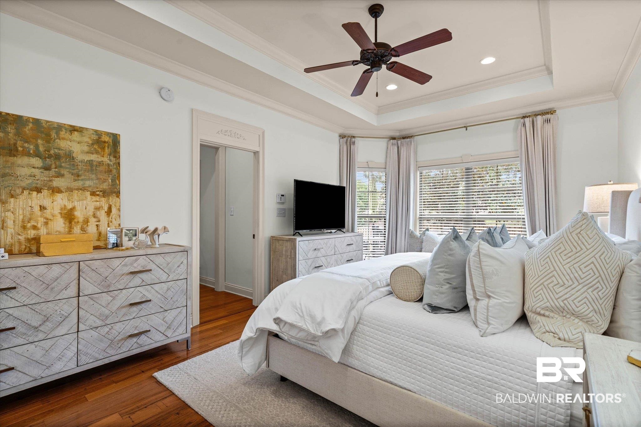 3459 Rue Royal Mobile, AL 36693 - Photo 15 of 31 Bright room featuring hardwood flooring, a multi-tiered tray ceiling, recessed lighting, a ceiling fan, and bay windows with blinds