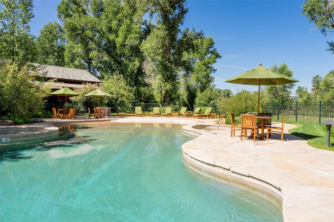 27200 Fire Song Road Steamboat Springs, CO 80487 - Photo 17 of 30 a view of a swimming pool with lawn chairs under an umbrella