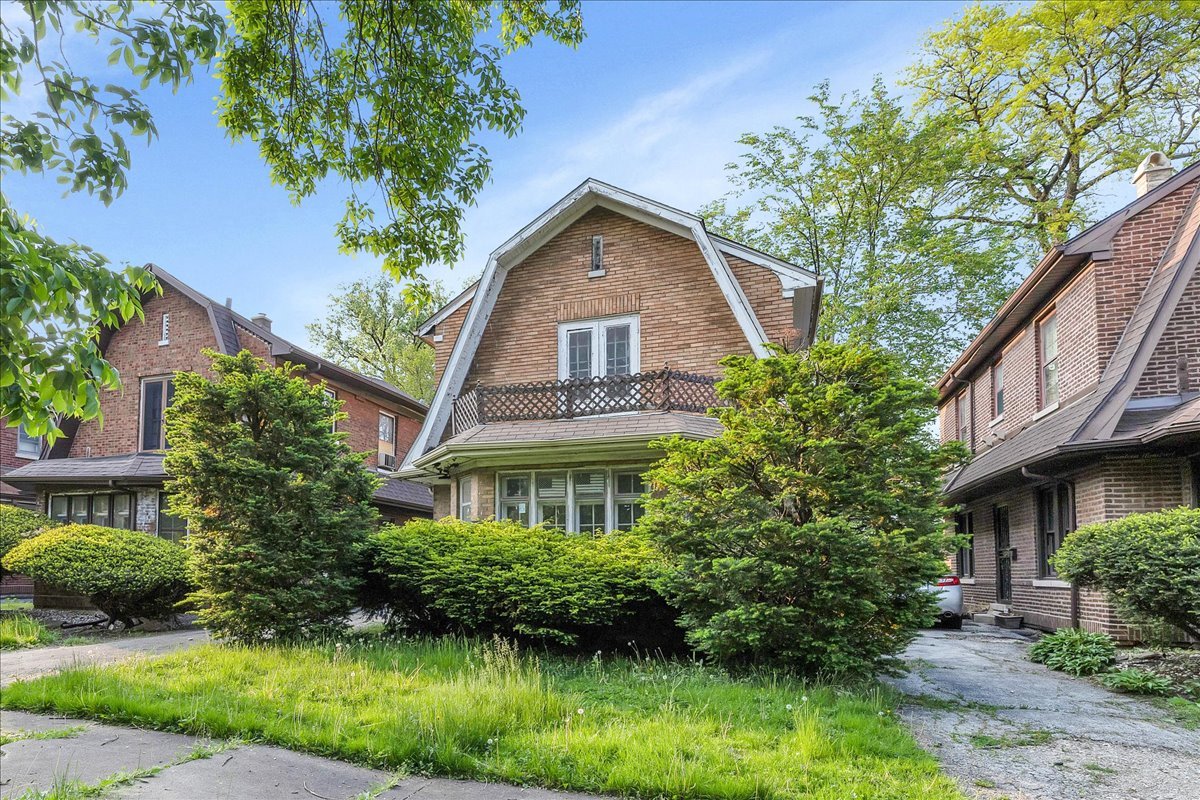 a front view of a house with a yard and potted plants
