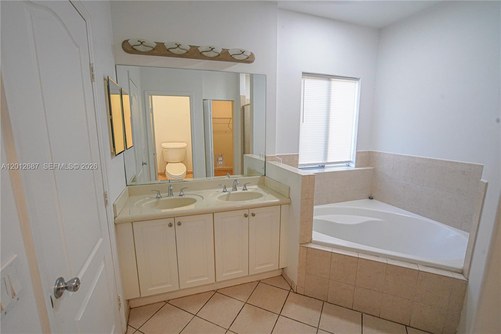 1751 Southwest 154th Path Miami, FL 33185 - Photo 18 of 41 a bathroom with a granite countertop sink a toilet and bathtub
