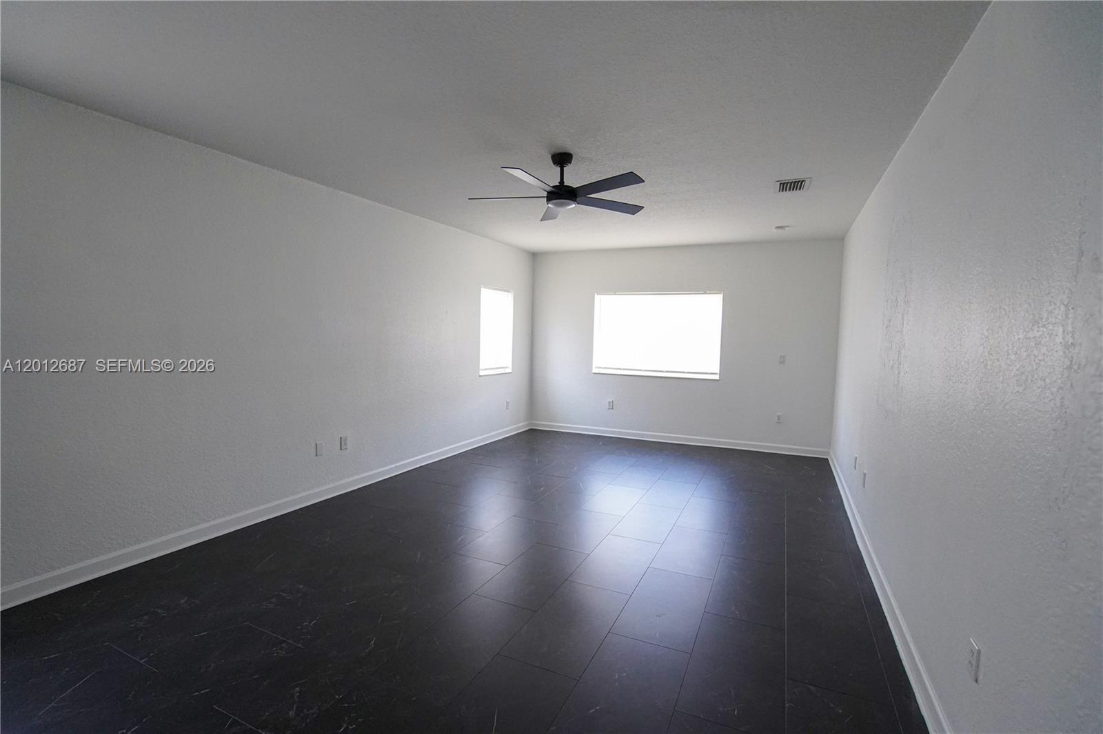 1751 Southwest 154th Path Miami, FL 33185 - Photo 28 of 41 an empty room with windows and ceiling fan