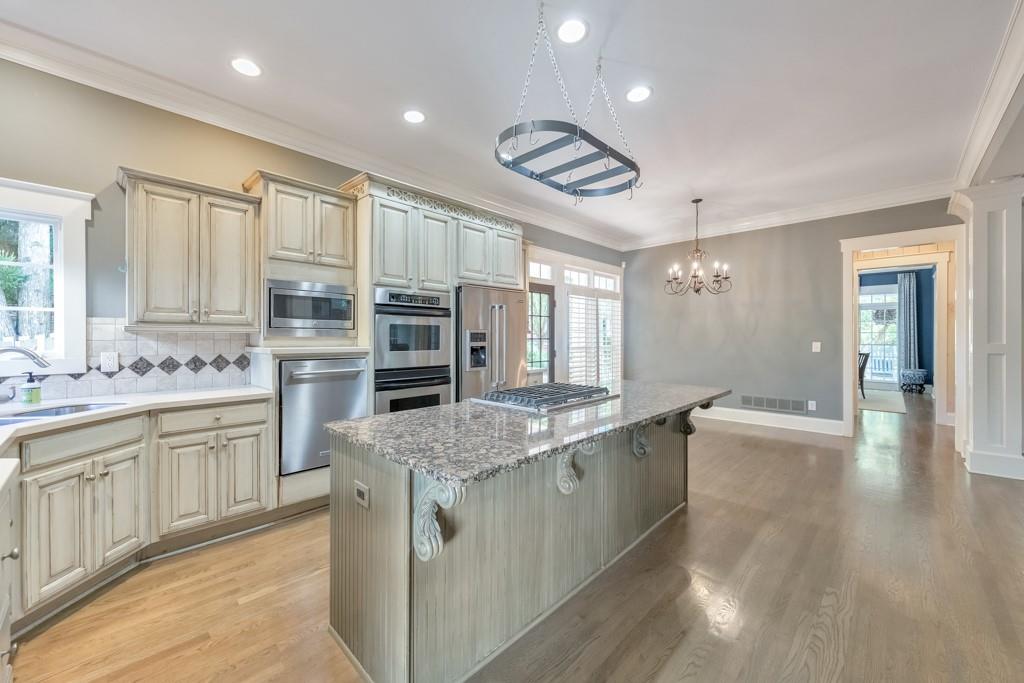 3901 Hazelhurst Drive Northeast Marietta, GA 30066 - Photo 3 of 79 a large kitchen with stainless steel appliances granite countertop a lot of counter space and wooden floors