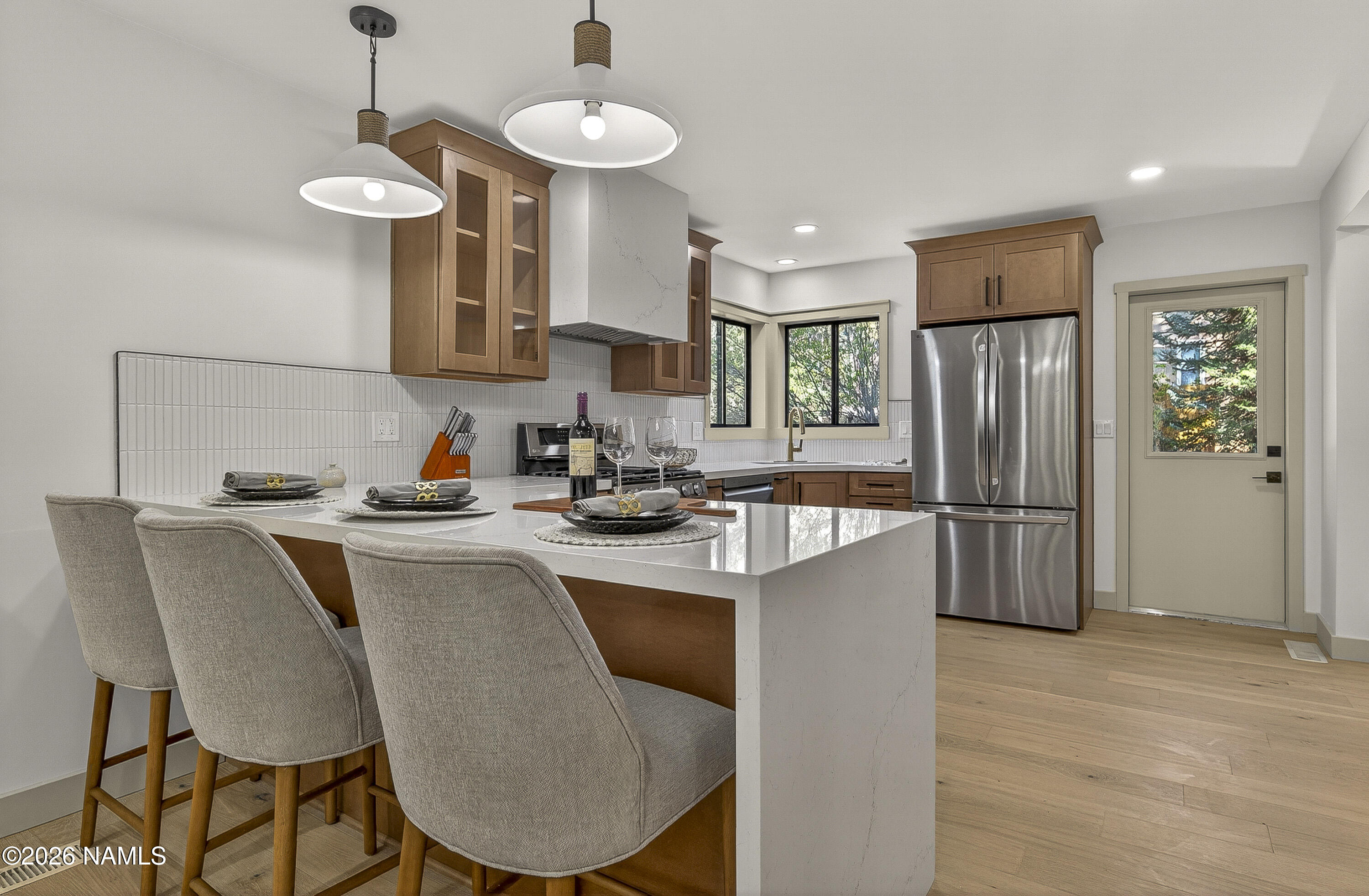 1411 Inverrary Way Flagstaff, AZ 86004 - Photo 17 of 49 a kitchen with stainless steel appliances granite countertop a refrigerator a sink dishwasher a stove a dining table and chairs with wooden floor