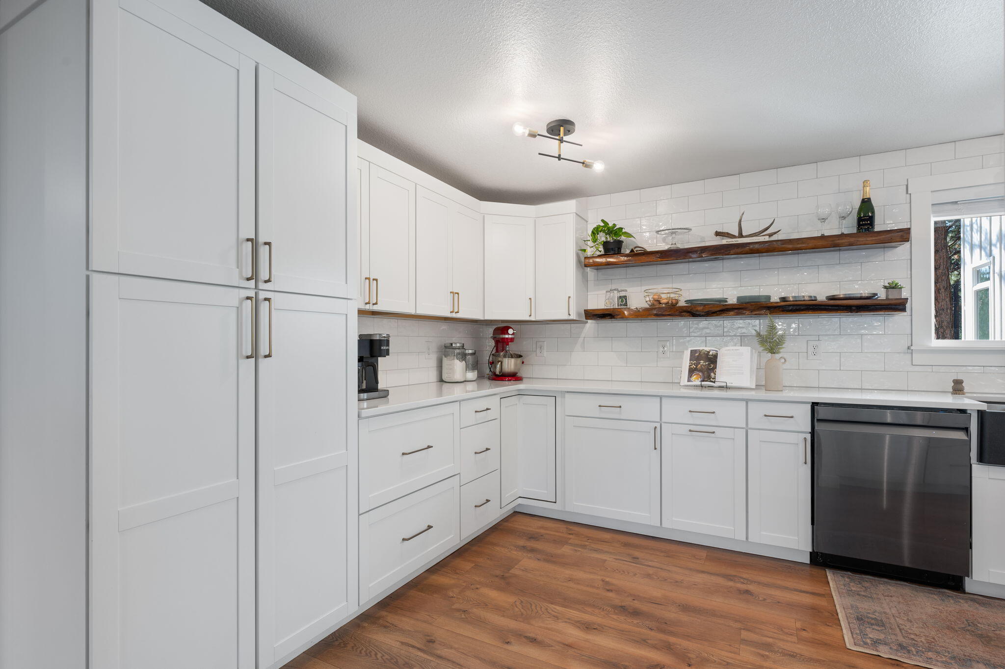 60072 Cinder Butte Road Bend, OR 97702 - Photo 28 of 60 a kitchen with stainless steel appliances granite countertop white cabinets a sink a stove a refrigerator and microwave with wooden floor