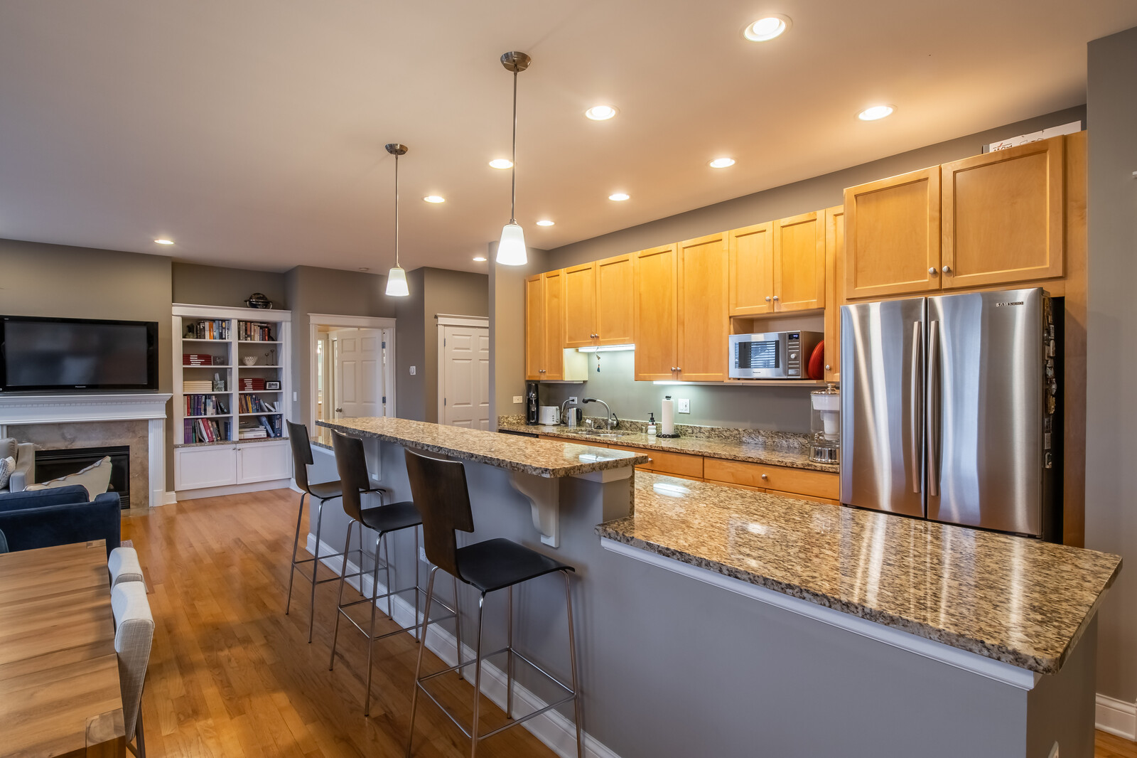 3755 North Racine Avenue, Unit 4E Chicago, IL 60613 - Photo 9 of 29 a kitchen with stainless steel appliances granite countertop a refrigerator a sink dishwasher a stove and a sink with wooden floor