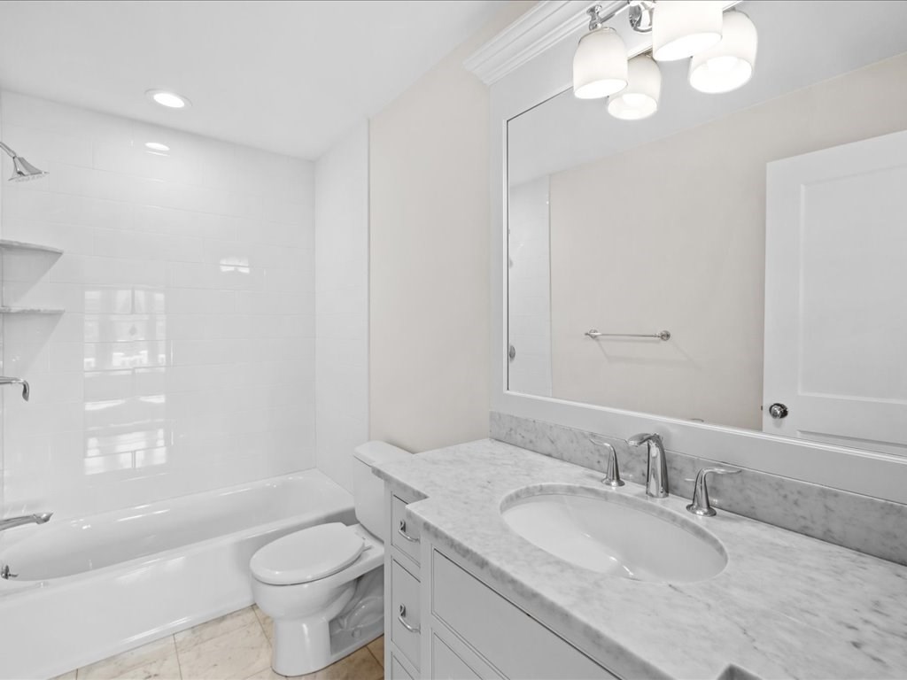 241 Bristol Road Wellesley, MA 02481 - Photo 23 of 42 a bathroom with a granite countertop sink a toilet a mirror a bathtub and shower