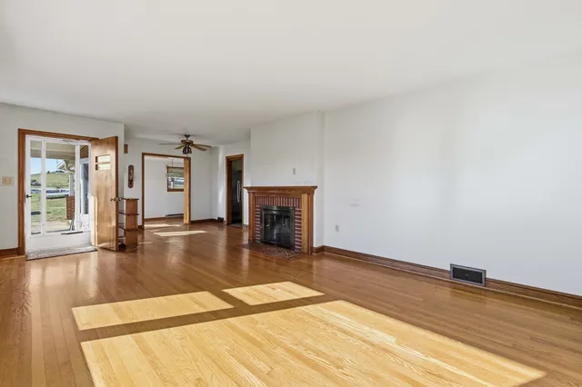 a view of empty room with wooden floor and fireplace