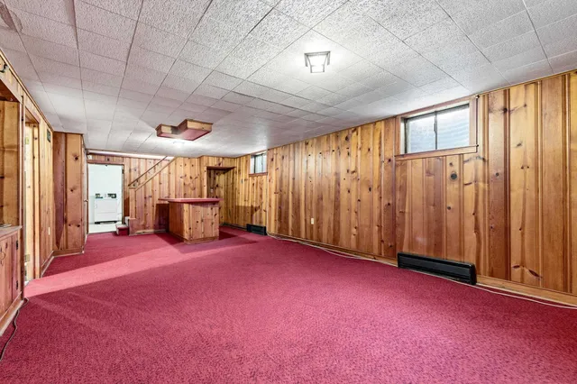 a view of a house with a large window and wooden fence