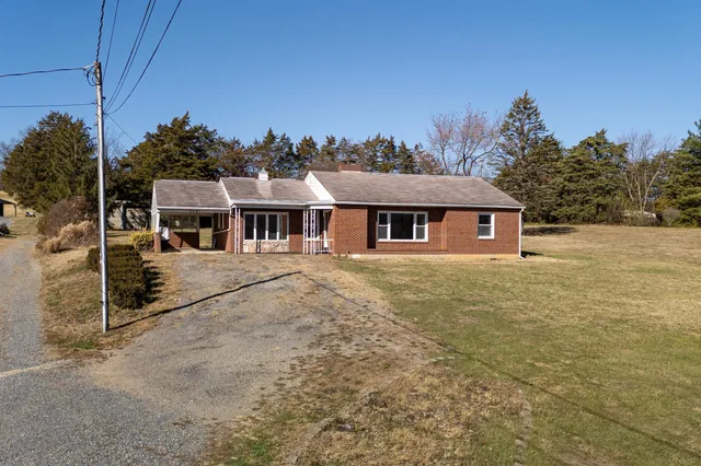 a view of a house with a yard covered in snow
