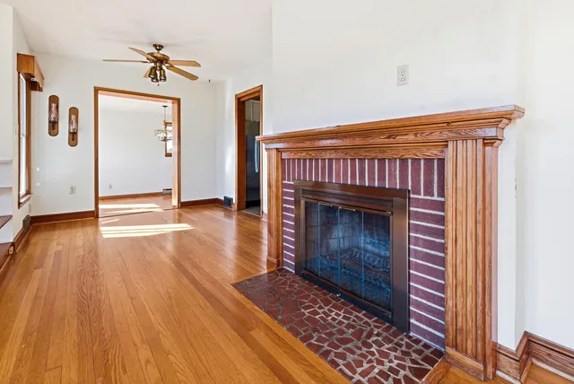 a view of an empty room with window wooden floor and a ceiling fan