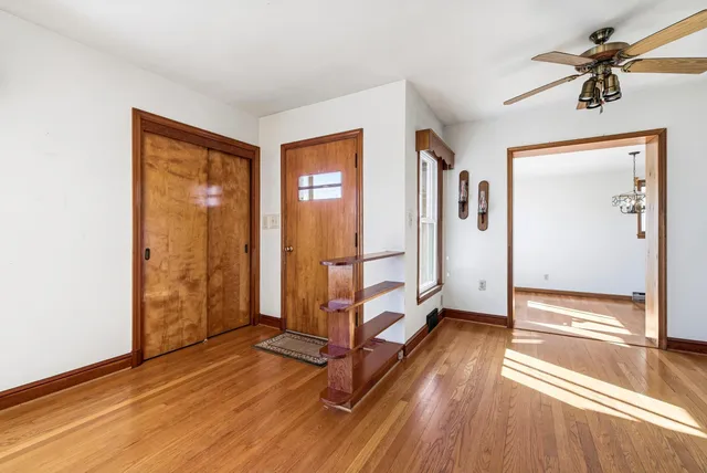a view of a livingroom with wooden floor and a ceiling fan