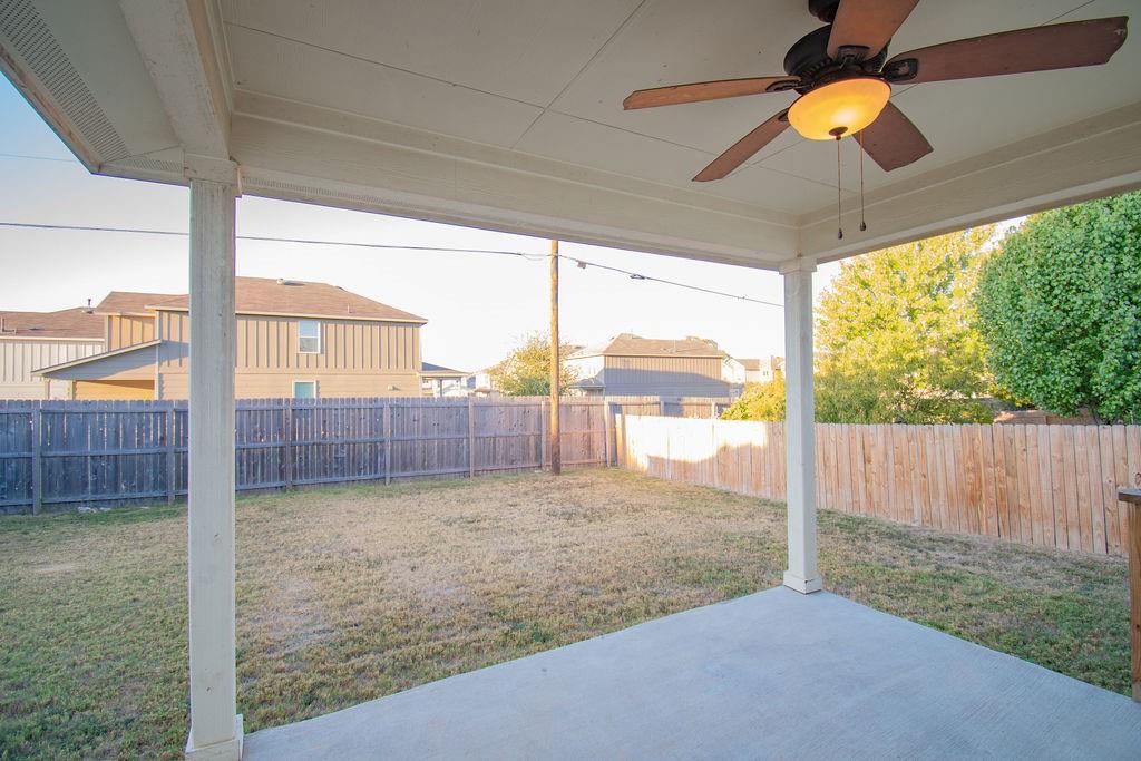 312 Pheasant Ridge Drive Round Rock, TX 78665 - Photo 30 of 34 An inviting covered patio offers a comfortable outdoor living space overlooking the fenced backyard.