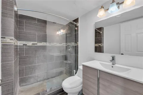 a bathroom with a sink mirror toilet and shower