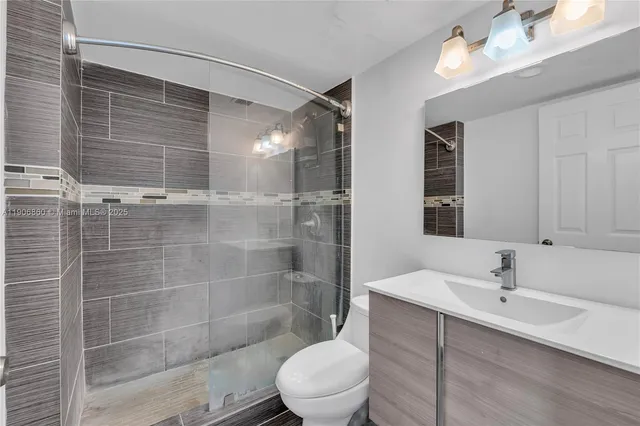 a bathroom with a sink mirror toilet and shower