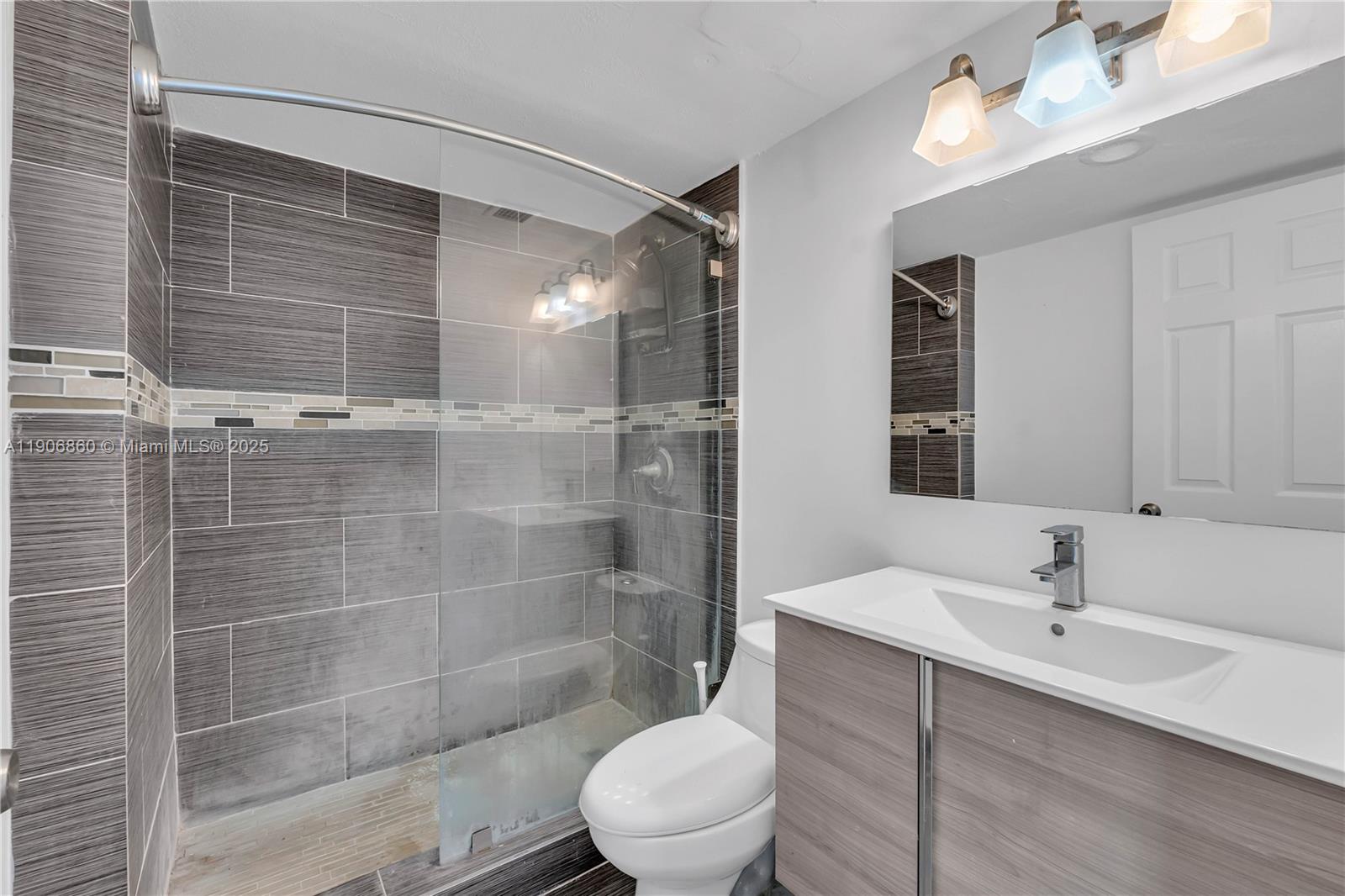 4164 Inverrary Drive, Unit 801 Lauderhill, FL 33319 - Photo 12 of 20 a bathroom with a sink mirror toilet and shower