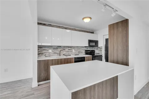 a kitchen with a refrigerator and a stove top oven