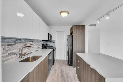 a kitchen with a refrigerator sink and wooden floor