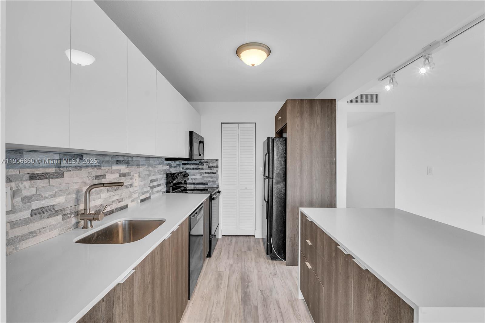 4164 Inverrary Drive, Unit 801 Lauderhill, FL 33319 - Photo 10 of 20 a kitchen with a refrigerator sink and wooden floor