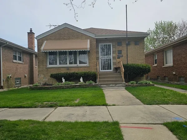 a front view of a house with a garden and plants