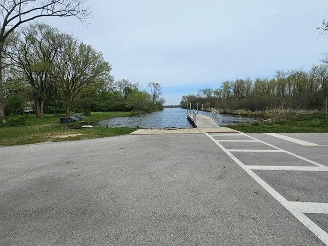 a view of a road with a yard and a large trees