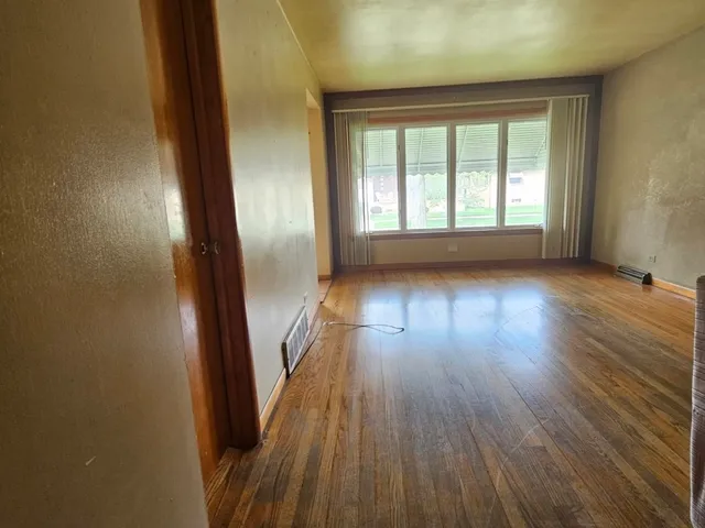 wooden floor in an empty room with a window