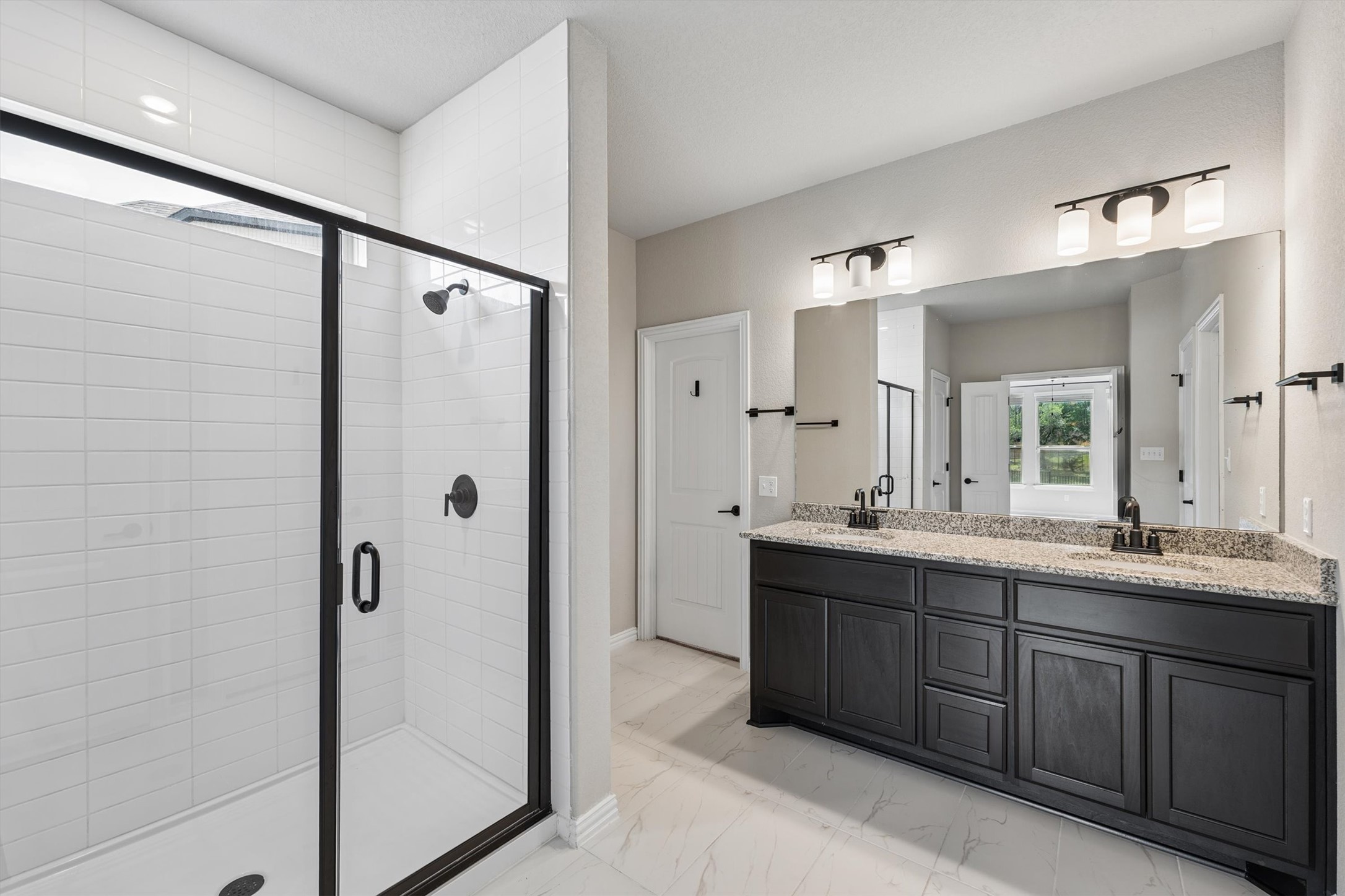 324 Autumn Oak Way Georgetown, TX 78628 - Photo 19 of 40 Spacious bathroom featuring a dual vanity with a stone countertop, dark cabinetry, and dual undermount sinks
