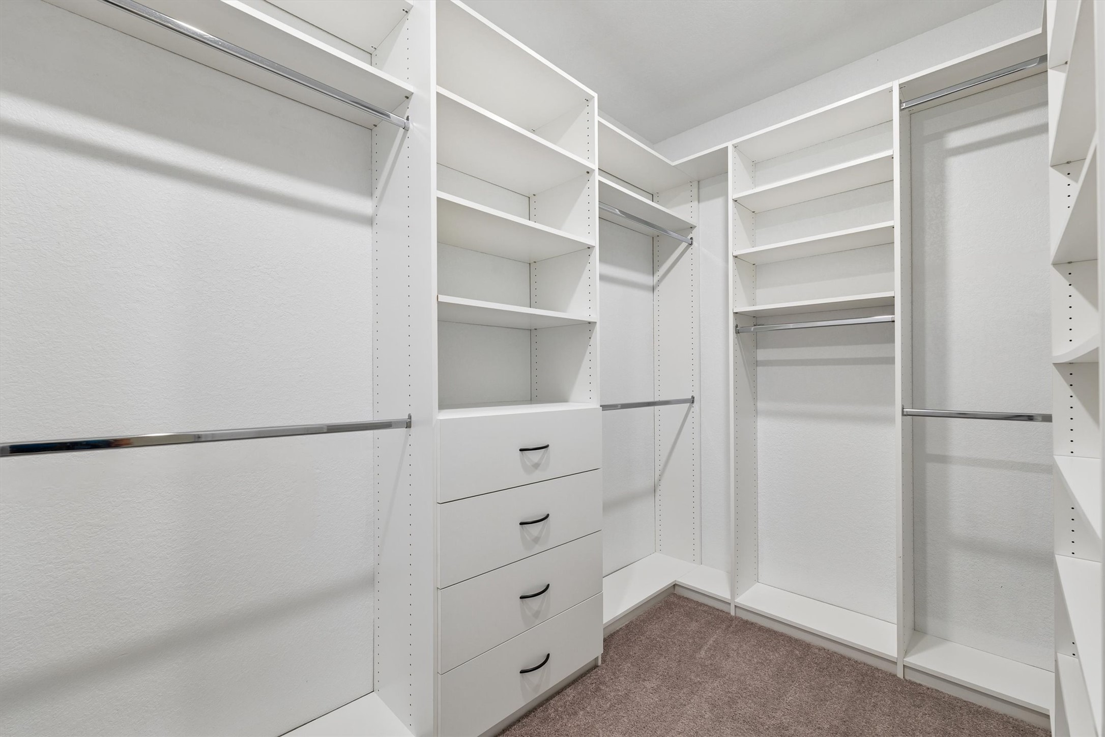 324 Autumn Oak Way Georgetown, TX 78628 - Photo 20 of 40 Custom closet organization system featuring multiple shelving units, chrome hanging rods, and integrated drawer storage