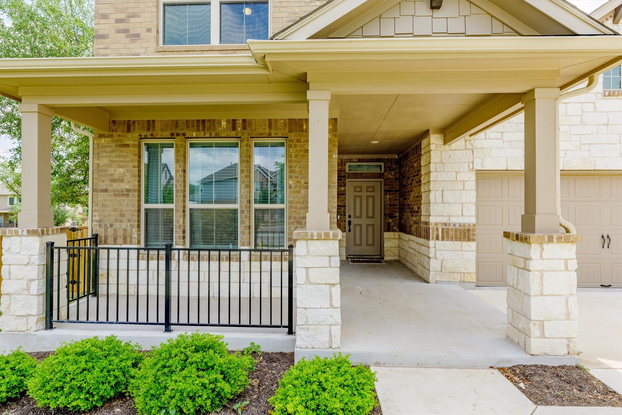 324 Autumn Oak Way Georgetown, TX 78628 - Photo 3 of 40 Inviting covered front porch with stone pillars and a black wrought iron railing