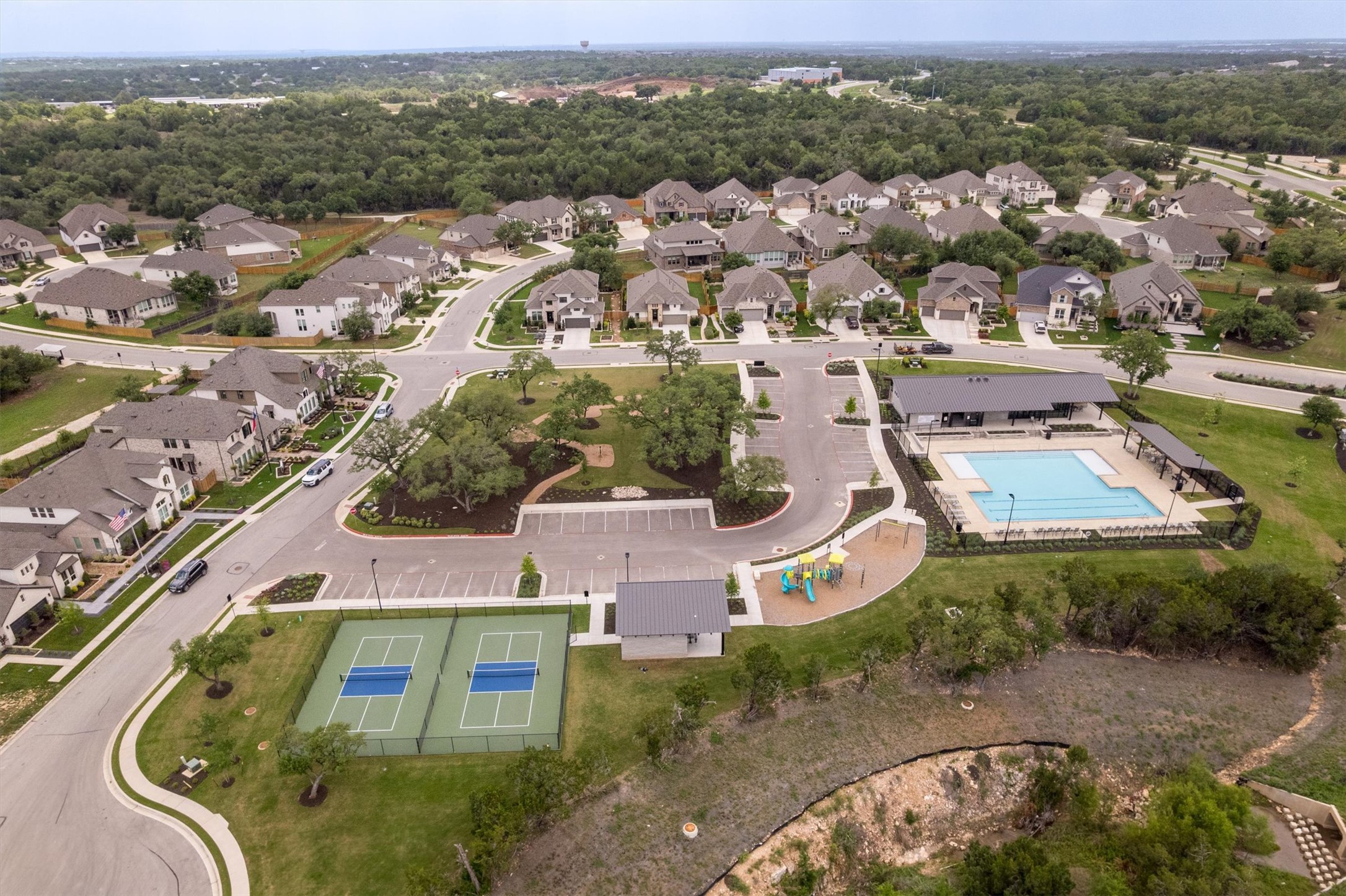 324 Autumn Oak Way Georgetown, TX 78628 - Photo 38 of 40 Community amenities including two pickleball courts, a playground, and a swimming pool with an adjacent clubhouse
