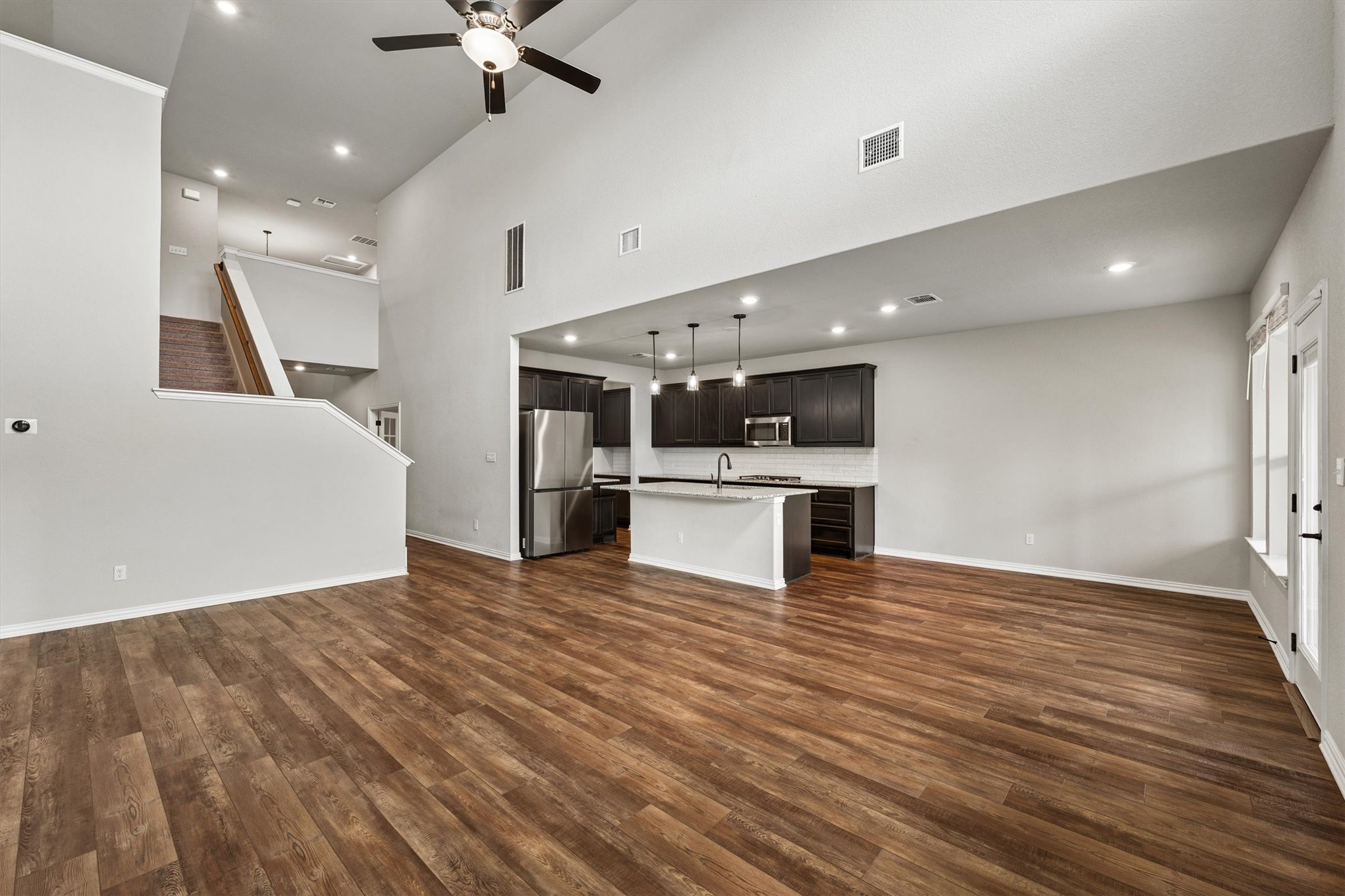 324 Autumn Oak Way Georgetown, TX 78628 - Photo 8 of 40 Expansive open-concept living area featuring wood-finish flooring, high ceilings with a ceiling fan, recessed lighting, and bright white walls