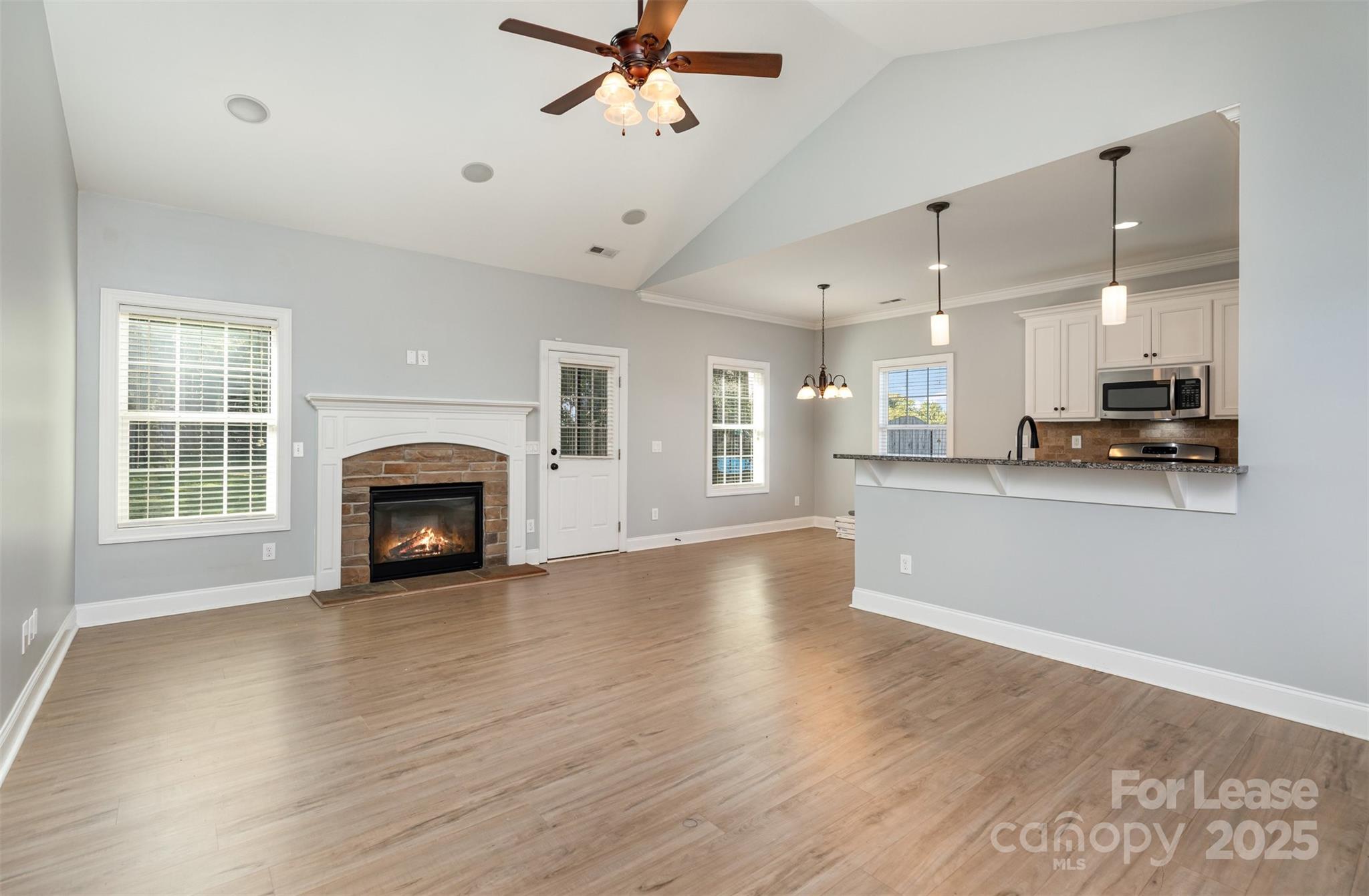 a view of empty room with wooden floor and fireplace