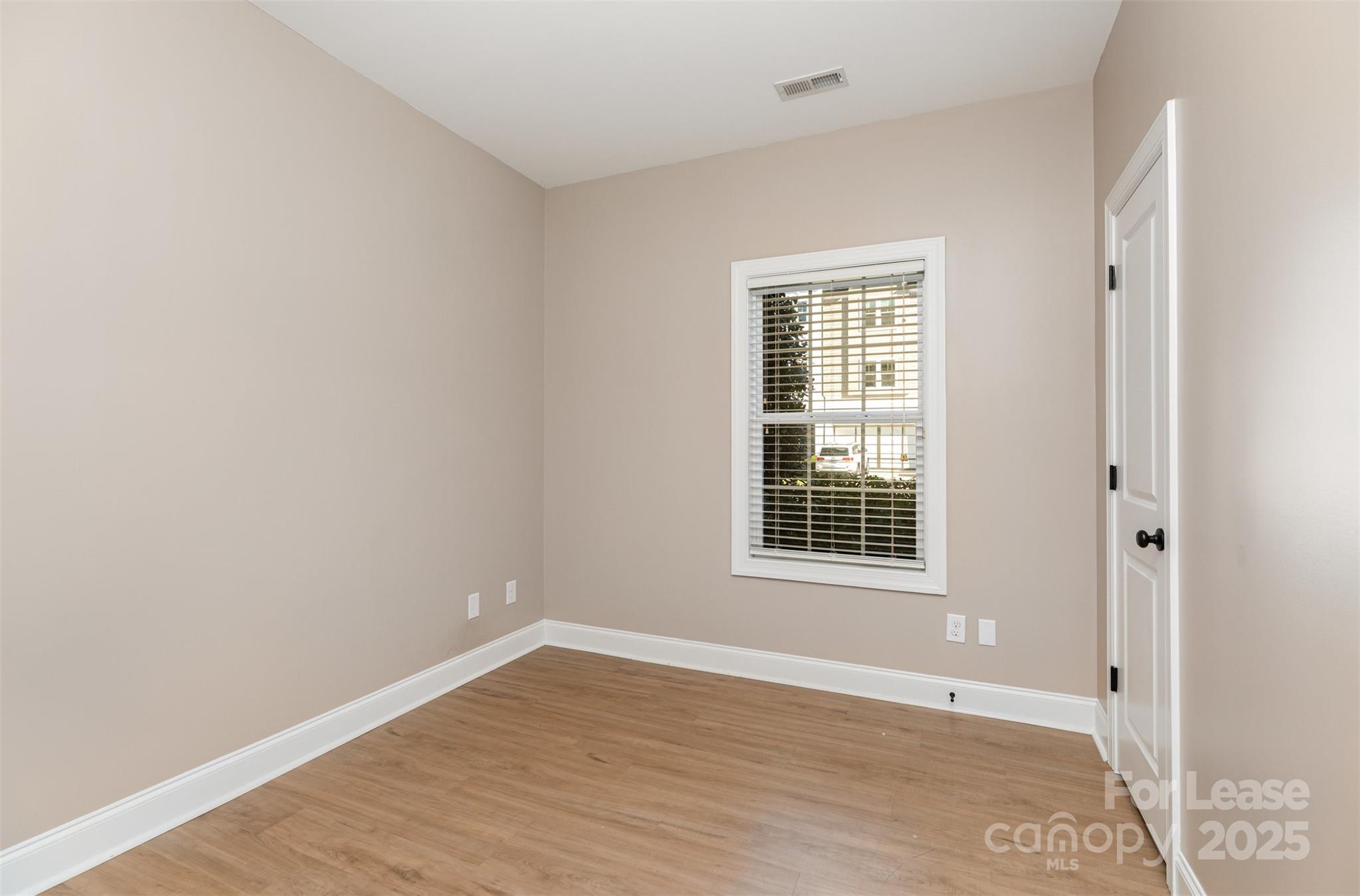 540 Greystone Road Charlotte, NC 28209 - Photo 13 of 18 a view of an empty room with wooden floor and a window