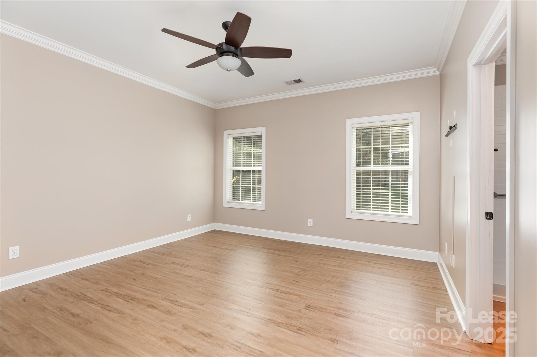 540 Greystone Road Charlotte, NC 28209 - Photo 10 of 18 an empty room with wooden floor fan and windows