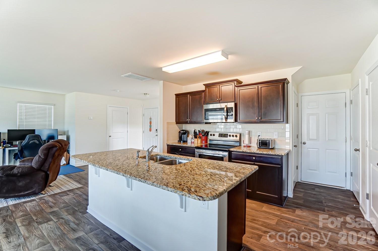 618 Bloomover Street Concord, NC 28025 - Photo 13 of 45 a kitchen with granite countertop kitchen island stainless steel appliances a sink stove and cabinets