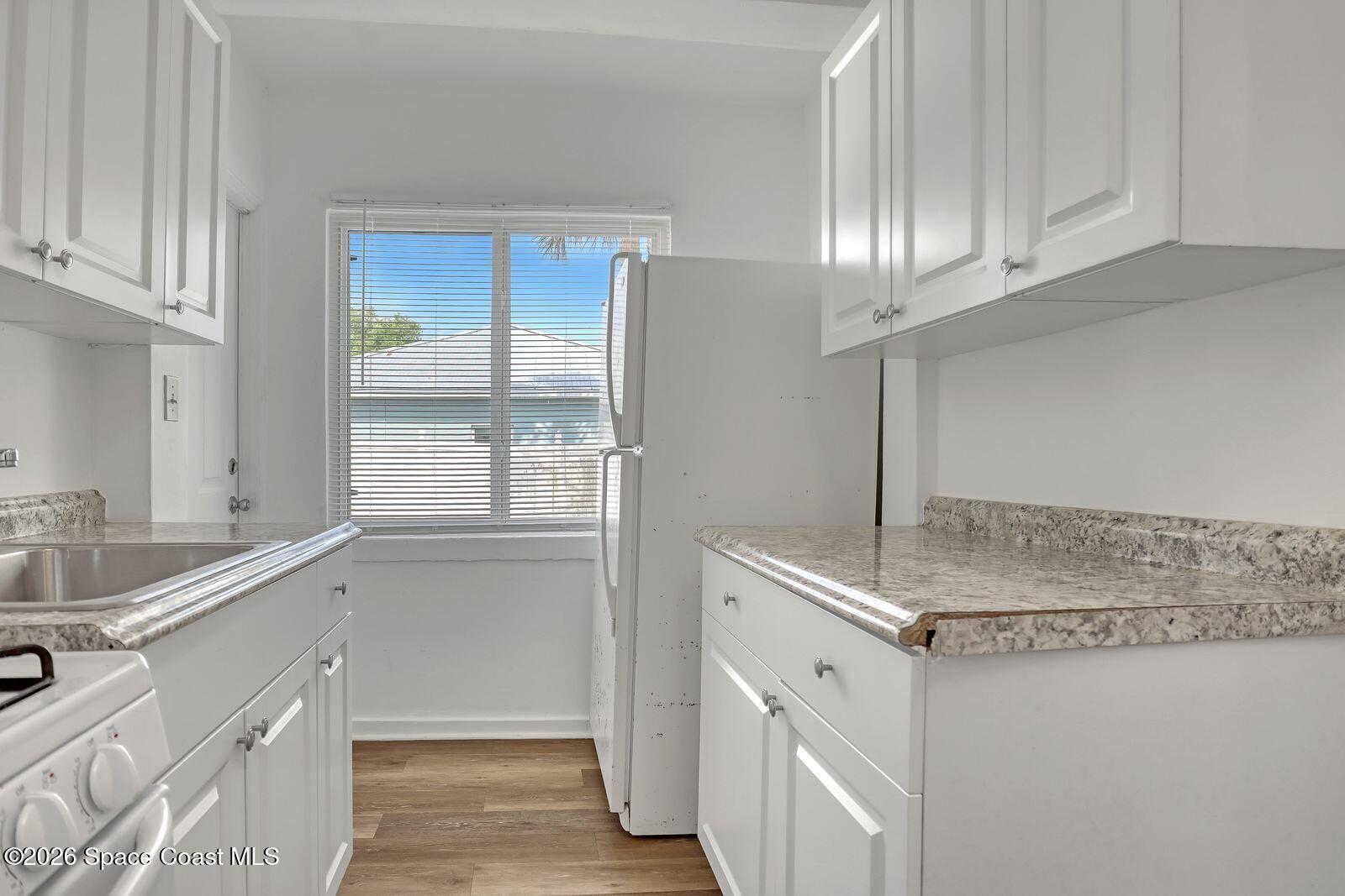 658 Young Street Melbourne, FL 32935 - Photo 15 of 77 a kitchen with stainless steel appliances granite countertop a sink and a refrigerator